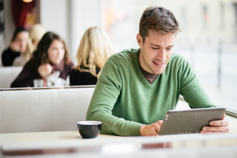 Man wearing green shirt using a tablet