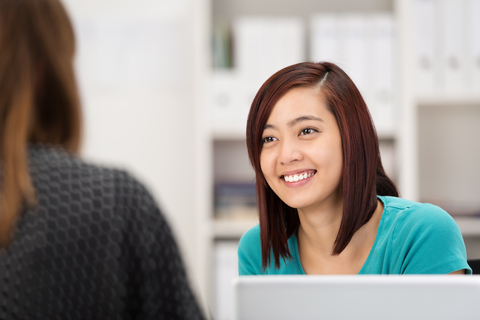 Service desk lady wearing blue and attending to customer wearing black